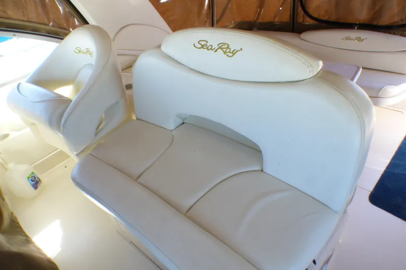 2002 Sea Ray 340 Sundancer interior with white leather seating and embroidered logo.