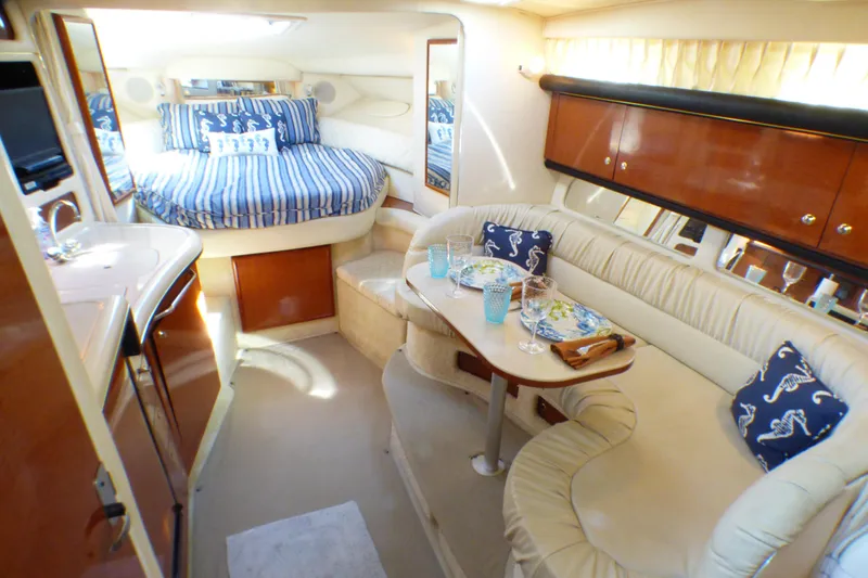Luxurious interior of 2002 Sea Ray 340 Sundancer with cozy seating and elegant dining area.