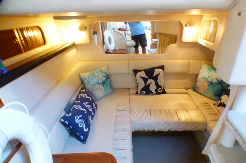 Interior of 2002 Sea Ray 340 Sundancer with cozy seating and decorative pillows.