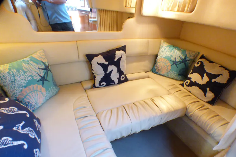 Interior of 2002 Sea Ray 340 Sundancer with nautical-themed cushions.