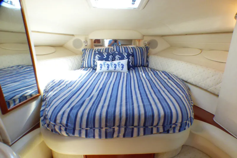 2002 Sea Ray 340 Sundancer cabin with striped bedding and seahorse pillow.