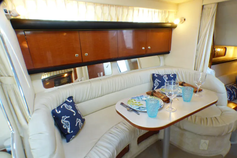 Luxurious interior of 2002 Sea Ray 340 Sundancer yacht with elegant dining setup.