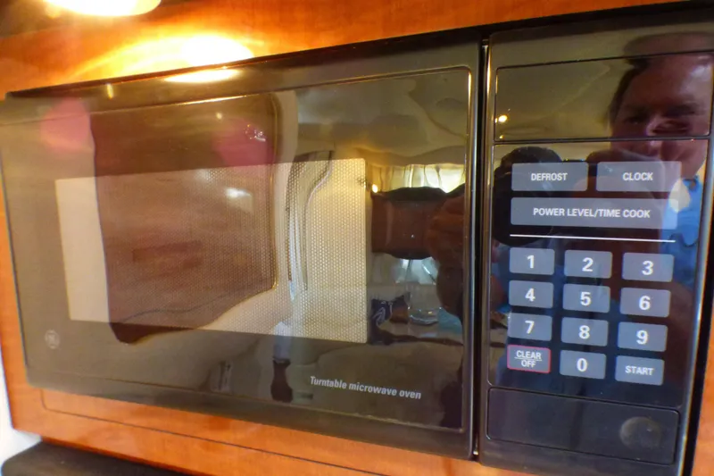 Microwave oven inside 2002 Sea Ray 340 Sundancer yacht, featuring digital controls and wood paneling.