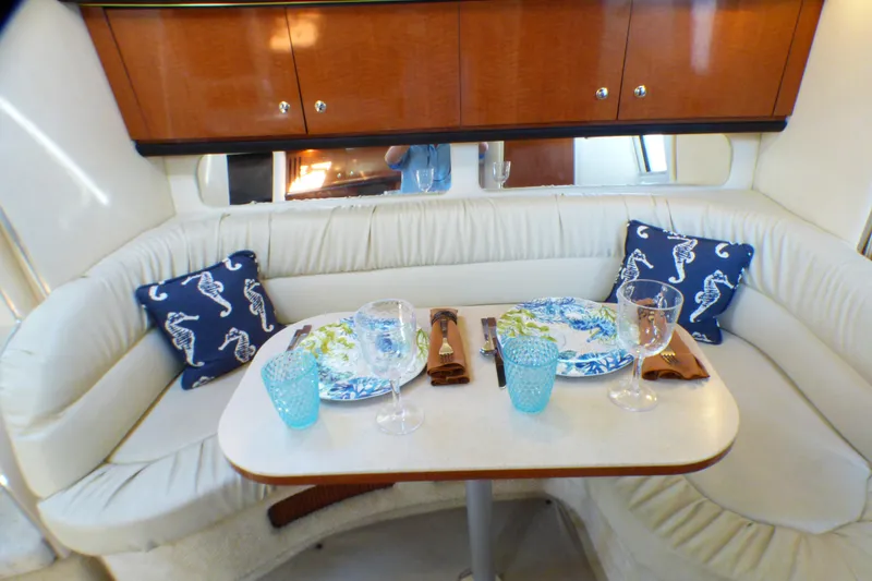 Luxurious dining area inside 2002 Sea Ray 340 Sundancer yacht with elegant table setting.