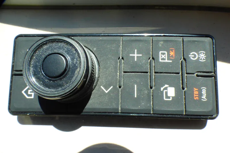 Control panel of a 2002 Sea Ray 340 Sundancer boat with various buttons and a knob.