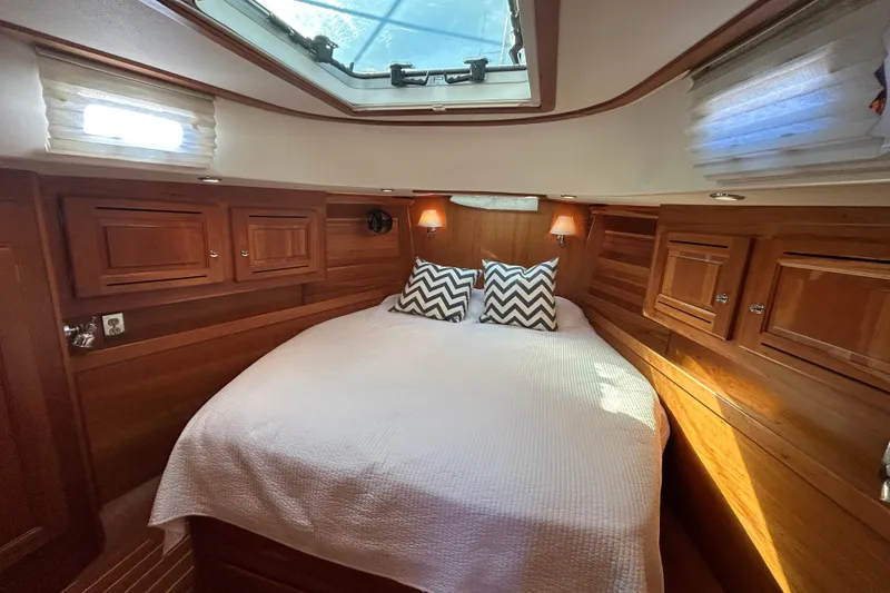 Luxurious 2003 Tartan 4400 LS yacht cabin with cozy bed and elegant wood finish.