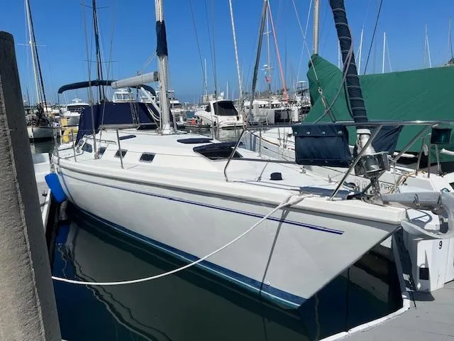 1999 Catalina 42 MkII sailboat docked at marina under clear blue sky.
