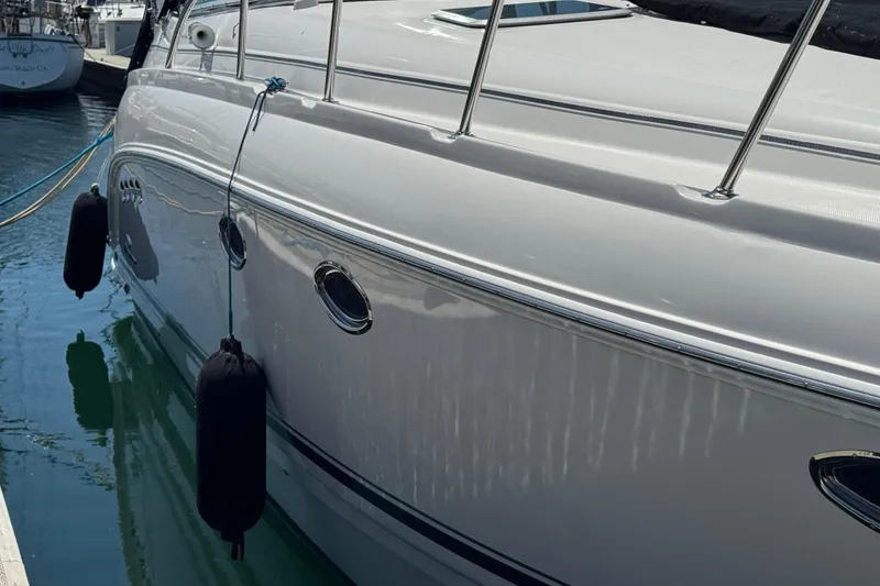 2006 Chaparral Signature 350 yacht docked with fenders, reflecting on calm water.