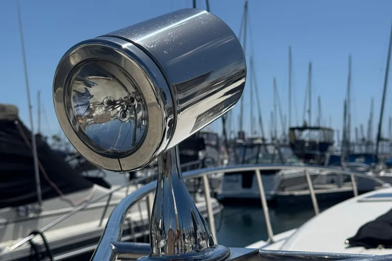 Chrome spotlight on 2006 Chaparral Signature 350 boat, marina background.
