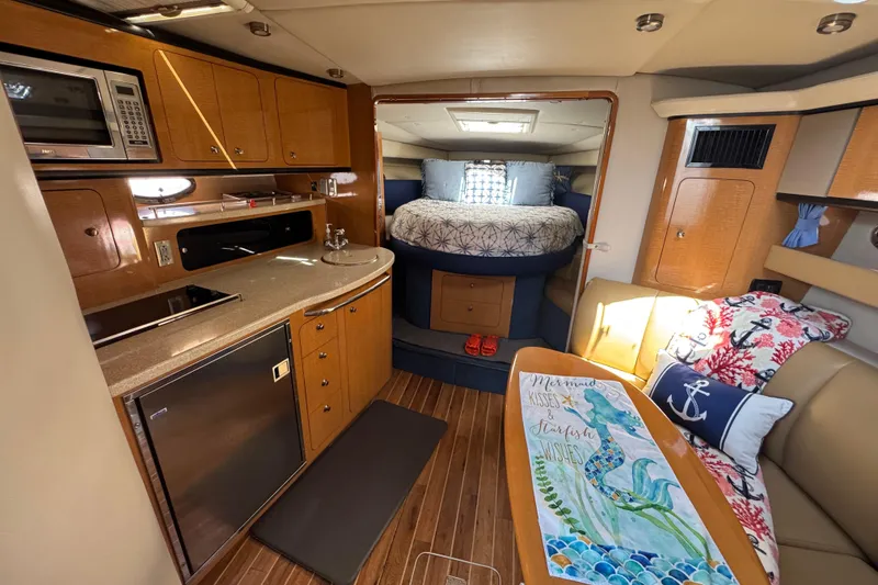 Interior of a 2006 Chaparral Signature 350 yacht with kitchen and cozy seating area.