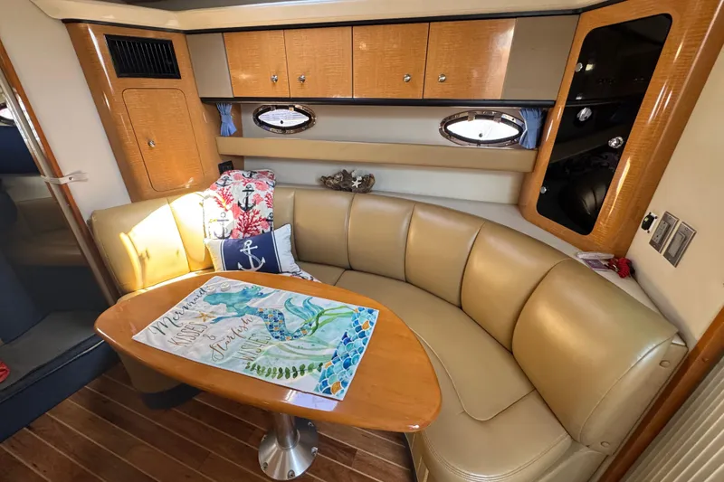 2006 Chaparral Signature 350 yacht interior with beige seating and wooden table.
