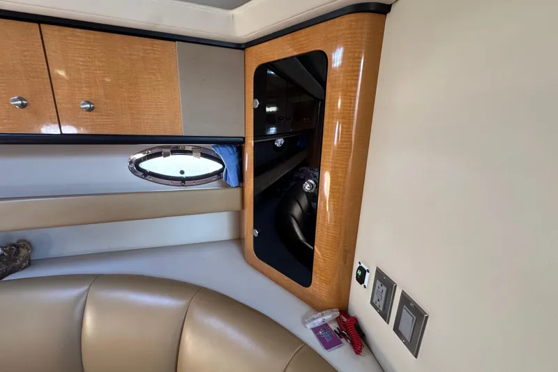 Interior of 2006 Chaparral Signature 350 yacht with wood cabinetry and porthole window.