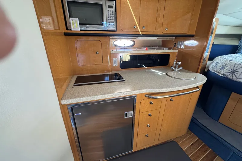 2006 Chaparral Signature 350 yacht interior kitchen with microwave, sink, and fridge.