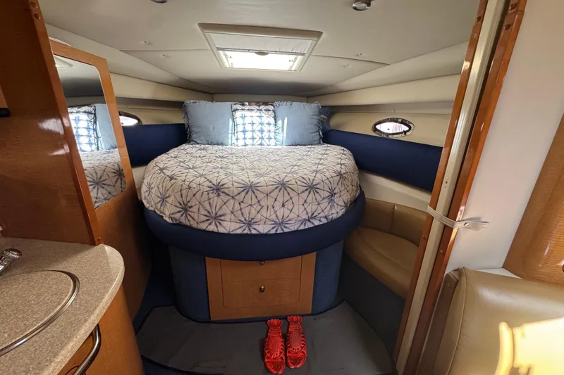 Interior cabin of a 2006 Chaparral Signature 350 boat with a cozy bed.