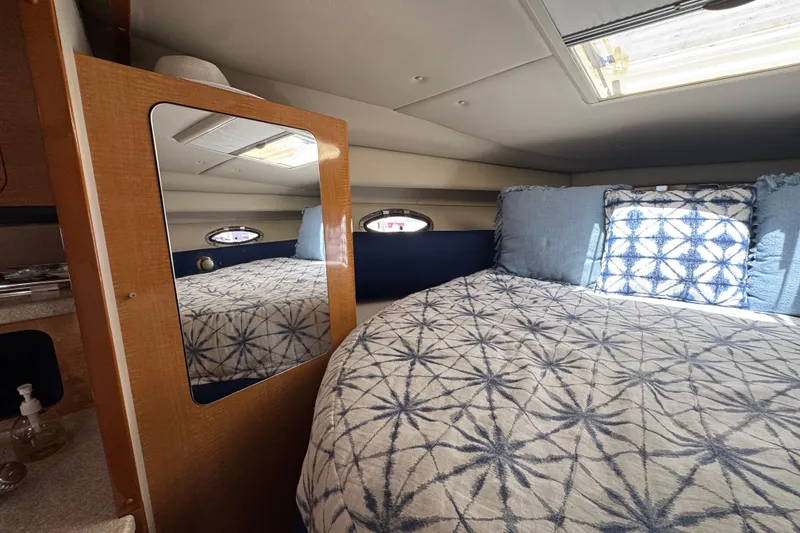 Interior cabin of 2006 Chaparral Signature 350 with patterned bedding and mirror.