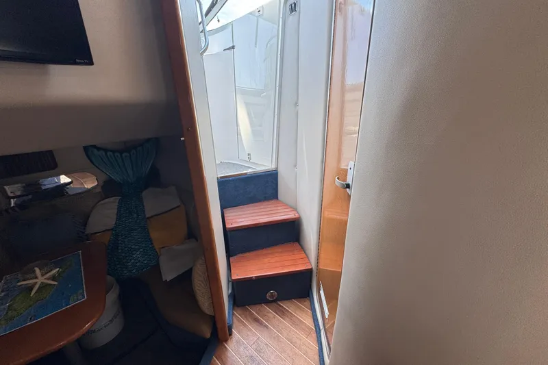 Interior view of 2006 Chaparral Signature 350 yacht with wooden steps and cozy seating area.