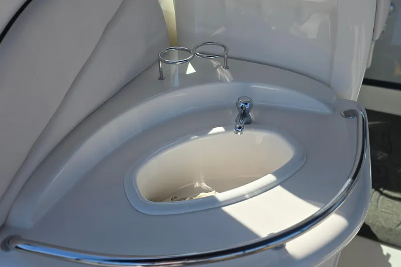 2005 Sea Ray 340 Sundancer boat sink with chrome faucet and cup holders.