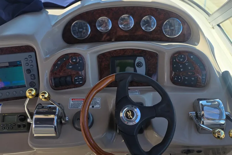 Control panel of a 2005 Sea Ray 340 Sundancer boat with steering wheel and gauges.