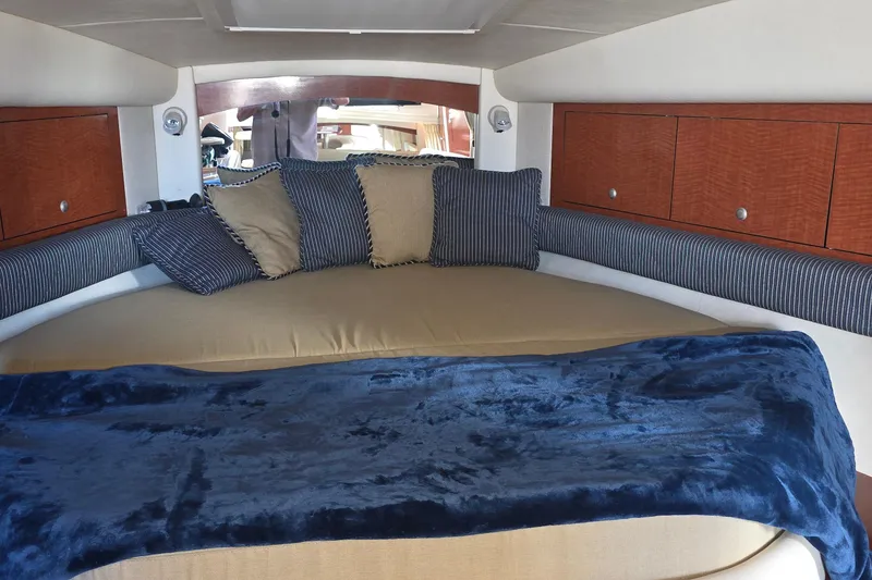 Interior cabin of 2005 Sea Ray 340 Sundancer with cozy bedding and cushions.