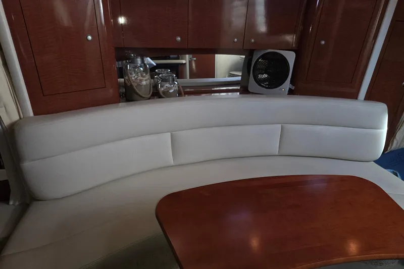 Interior of 2005 Sea Ray 340 Sundancer with curved seating and wooden table.