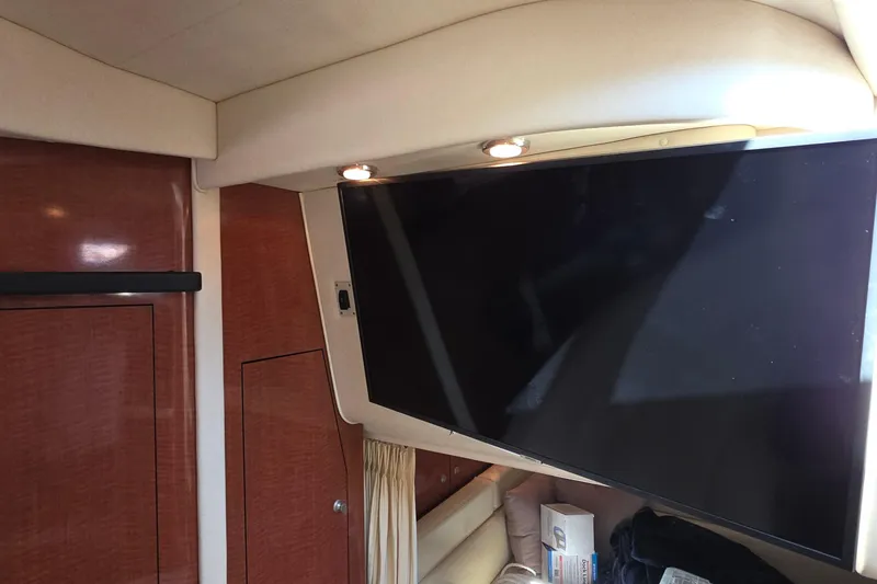 Interior of 2005 Sea Ray 340 Sundancer with mounted TV and wood paneling.