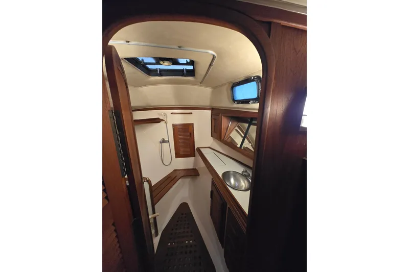 Interior of 1979 Islander Freeport 36 sailboat, featuring a compact bathroom with wooden accents.