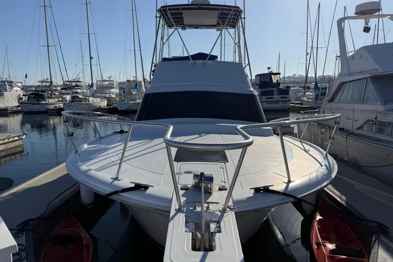 1998 Luhrs Tournament 320 Convertible yacht docked in a marina, surrounded by other boats.