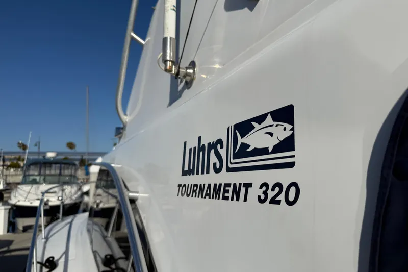 1998 Luhrs Tournament 320 Convertible boat docked, showcasing logo and sleek design.