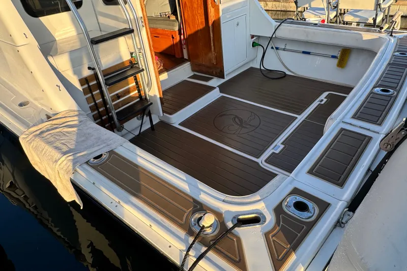 1998 Luhrs Tournament 320 Convertible boat deck with ladder and wooden flooring.