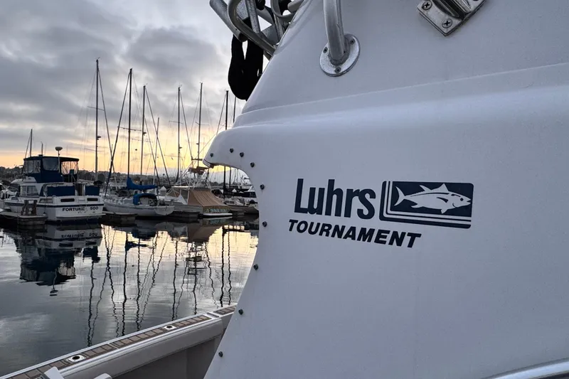 1998 Luhrs Tournament 320 Convertible boat docked at marina during sunset.