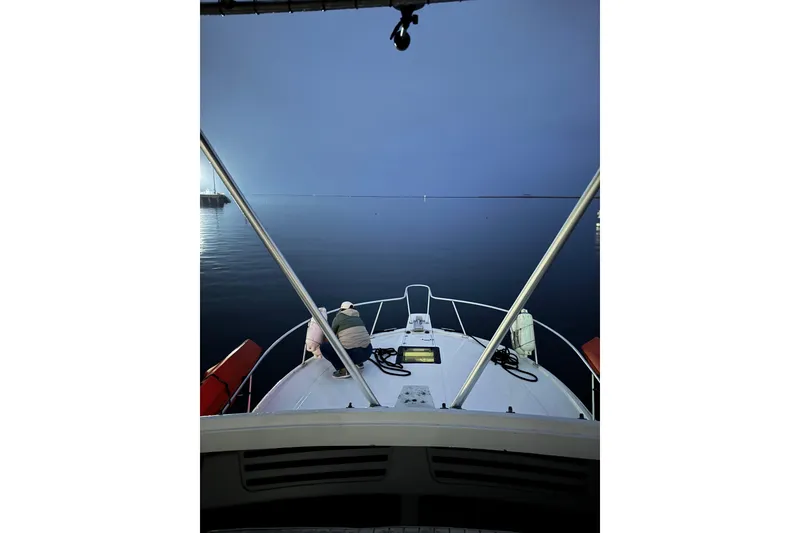 1998 Luhrs Tournament 320 Convertible boat on calm water at dusk.