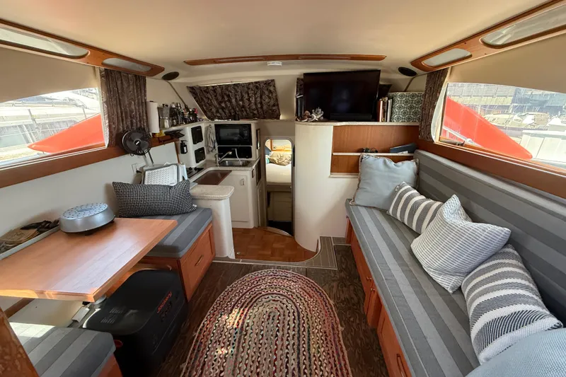 Interior of 1998 Luhrs Tournament 320 Convertible boat, featuring cozy seating and a compact kitchen.