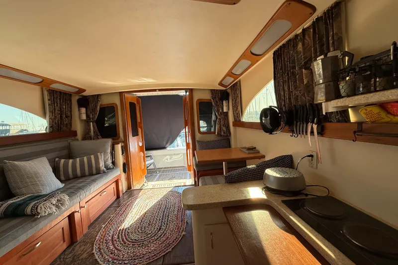 Interior of 1998 Luhrs Tournament 320 Convertible boat, featuring cozy seating and kitchenette.