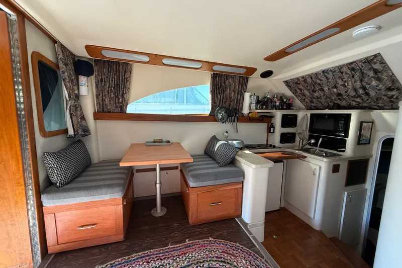 Interior of 1998 Luhrs Tournament 320 Convertible boat with cozy dining and kitchen area.