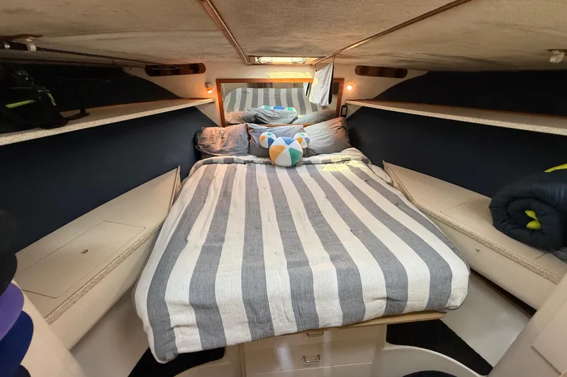 1998 Luhrs Tournament 320 Convertible cabin with striped bedding and cozy interior.
