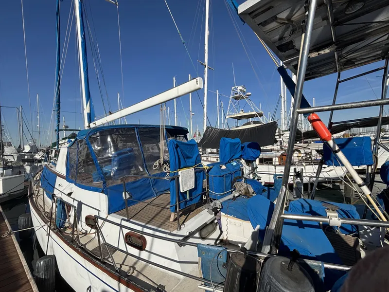1973 CAL 246 sailboat docked at marina, featuring blue covers and clear skies.