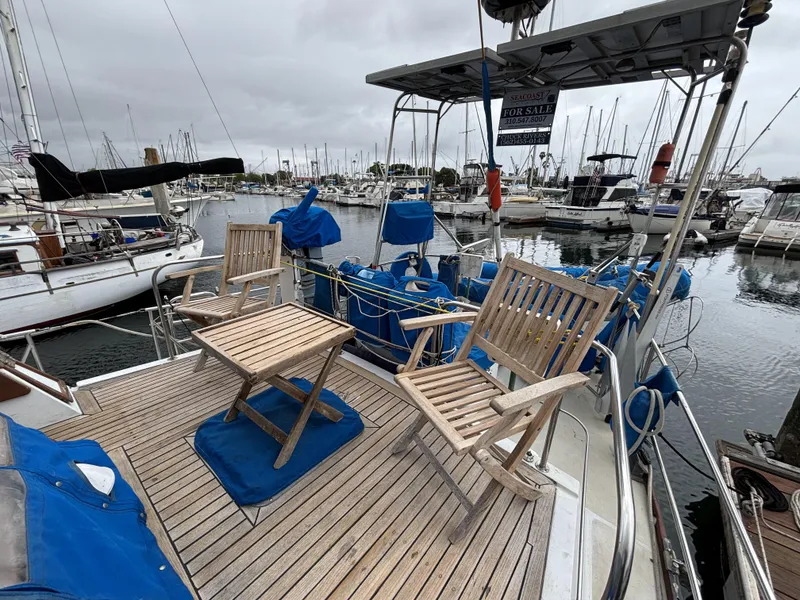 1973 CAL 246 sailboat with wooden deck chairs, docked in a marina.