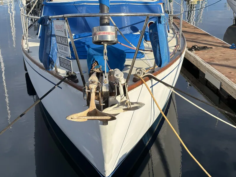 1973 CAL 246 sailboat docked, featuring blue covers and anchor, for sale sign visible.