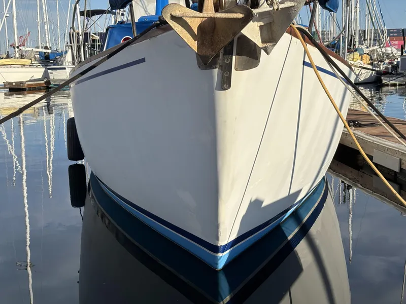 Front view of a 1973 CAL 246 sailboat docked in a marina.