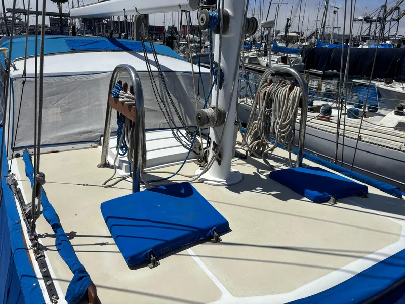 1973 CAL 246 sailboat deck with blue cushions and rigging in a marina.