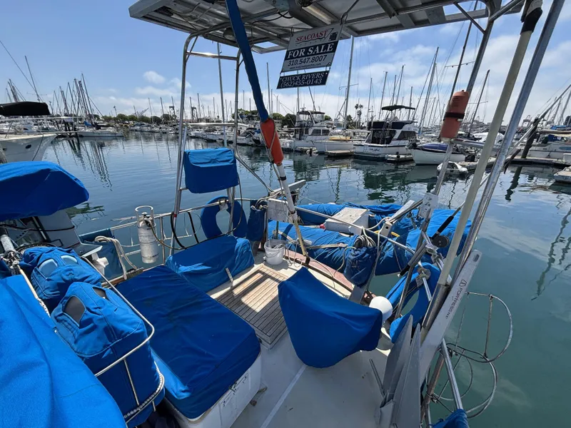 1973 CAL 246 sailboat with blue seating, docked in marina, for sale sign visible.