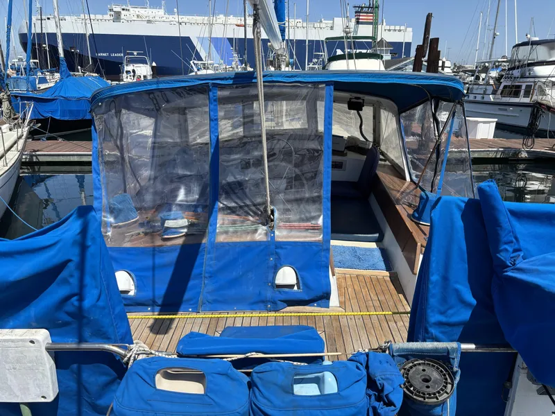 1973 CAL 246 sailboat with blue covers docked at a marina.
