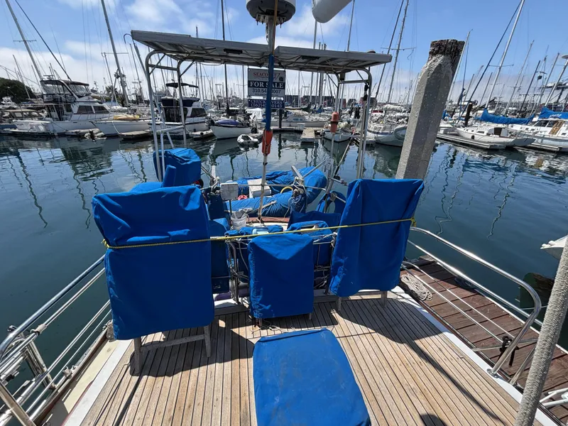 1973 CAL 246 sailboat with blue covers docked in a marina.