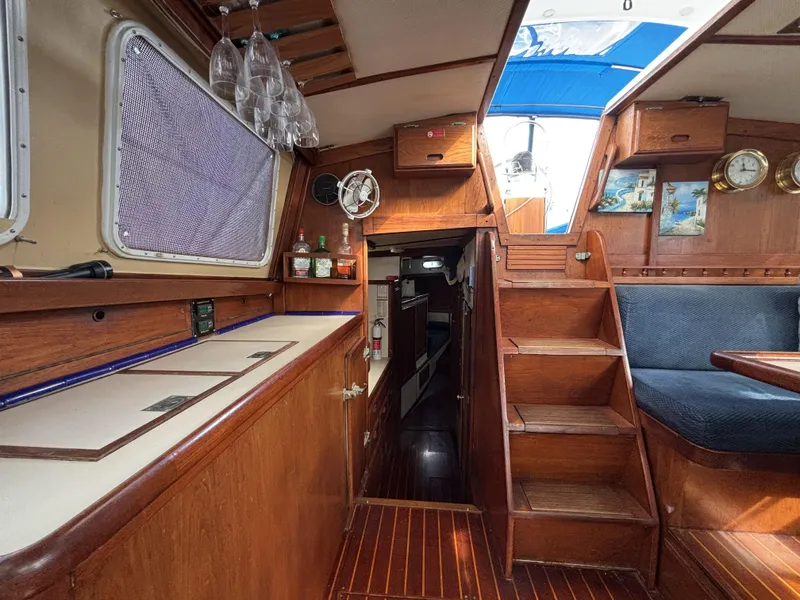 Interior of a 1973 CAL 246 sailboat with wooden finishes and nautical decor.