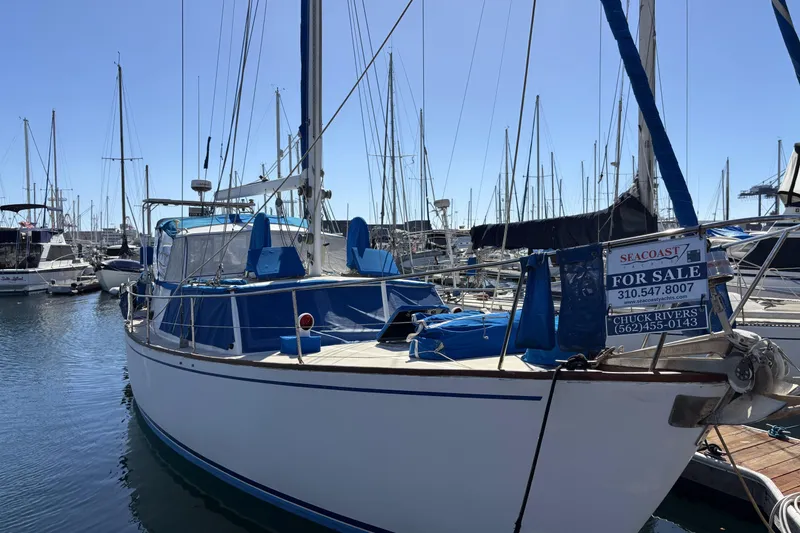 1973 CAL 246 sailboat for sale at marina, featuring blue accents and contact information.