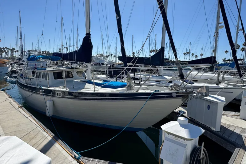 1988 Gulf Pilot House sailboat docked at marina, surrounded by other vessels.