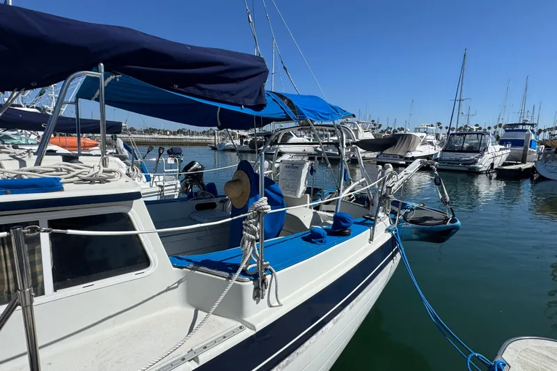 1988 Gulf Pilot House boat docked in a marina under clear blue skies.