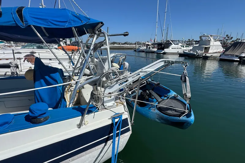 1988 Gulf Pilot House boat docked with blue kayak and marina view.