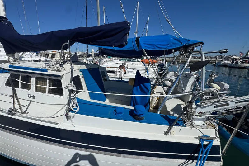 1988 Gulf Pilot House boat docked in marina, featuring blue and white design.