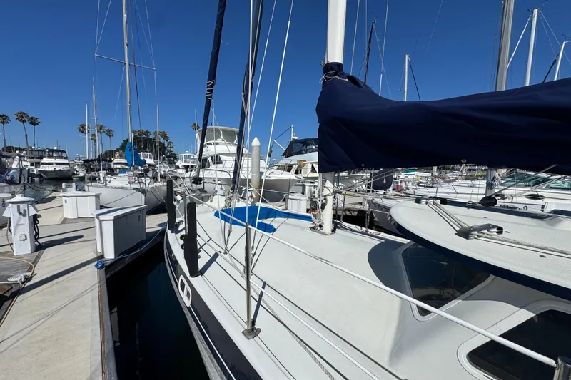 1988 Gulf Pilot House sailboat docked in a marina under clear blue skies.